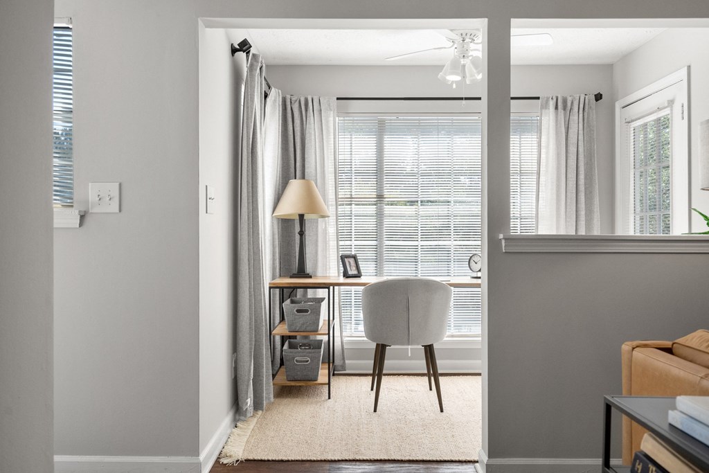 a home office with a desk and chair in front of a window