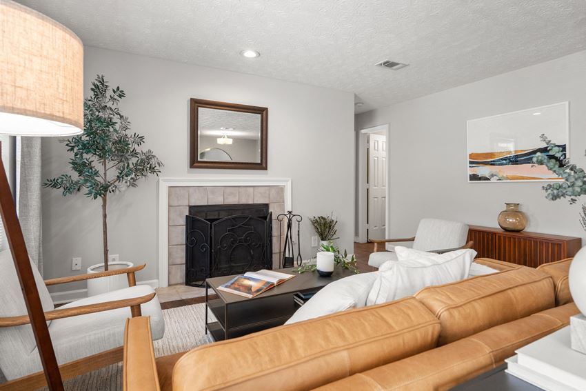 a living room with a leather couch and a fireplace