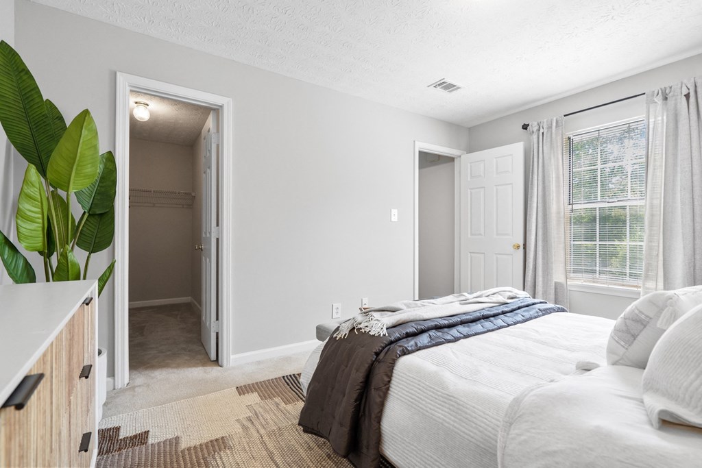 a bedroom with a bed and a closet      and a hallway