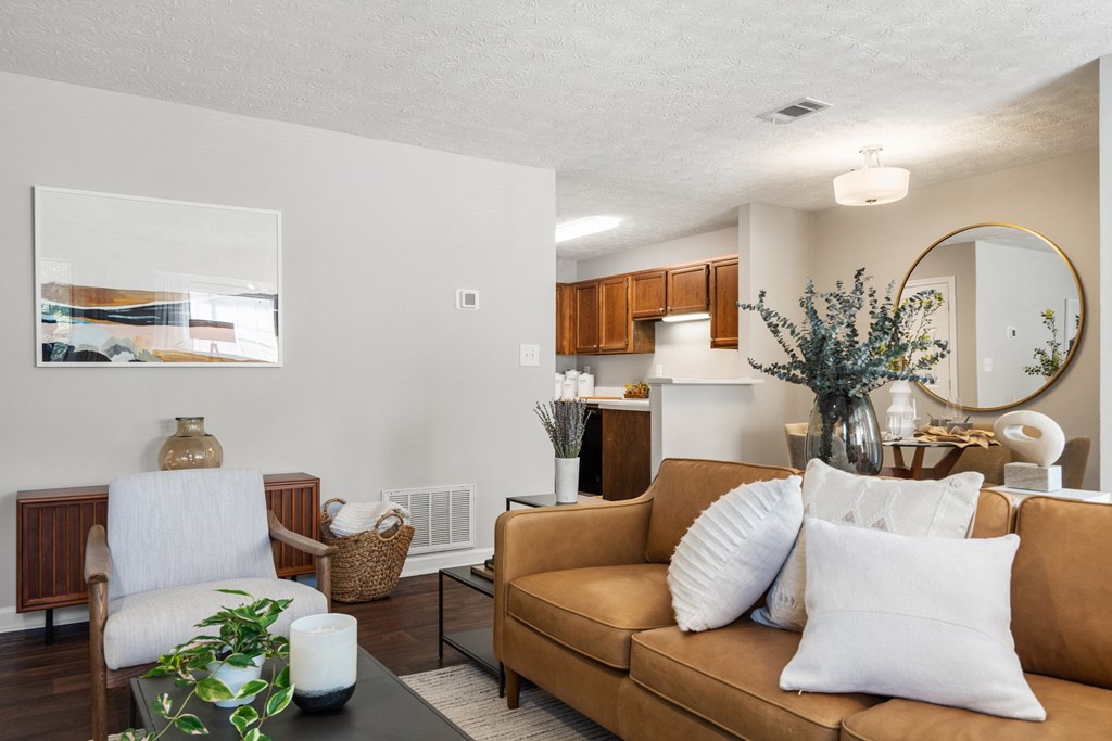 a living room with a couch and a chair and a kitchen