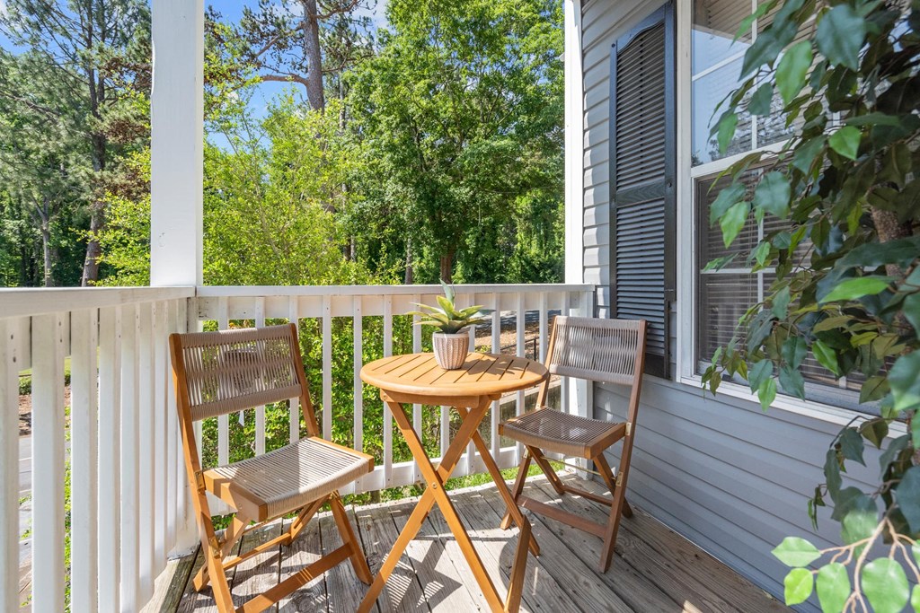 a patio with two chairs and a table on a porch