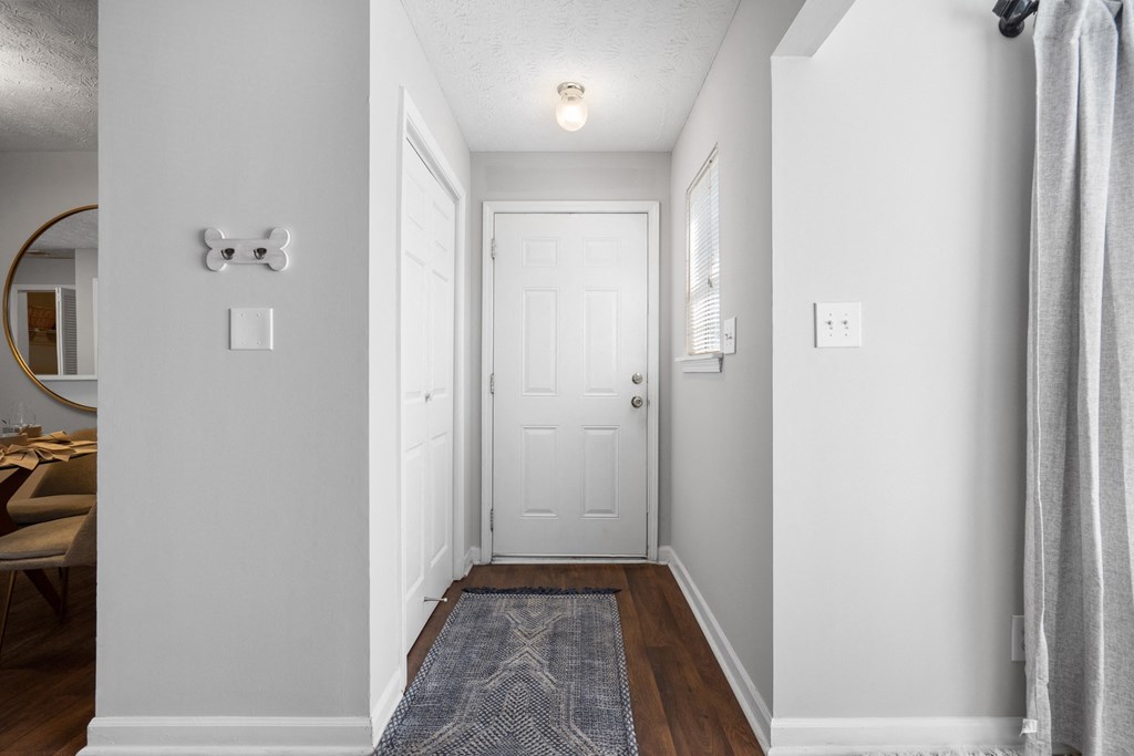 a hallway with a white door and a door to a closet