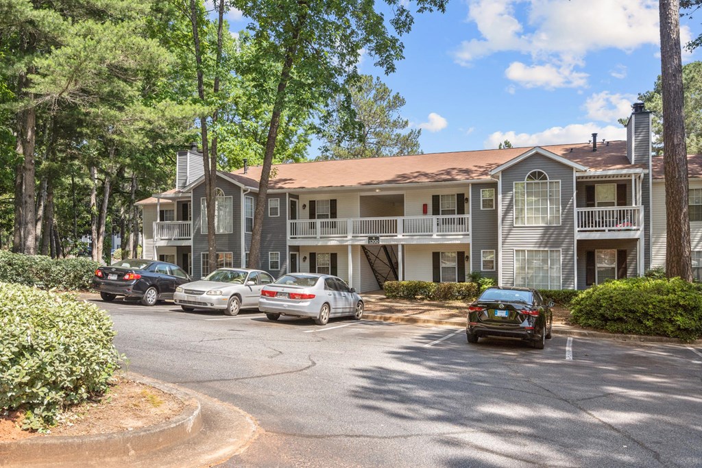 an apartment building with cars parked in a parking lot
