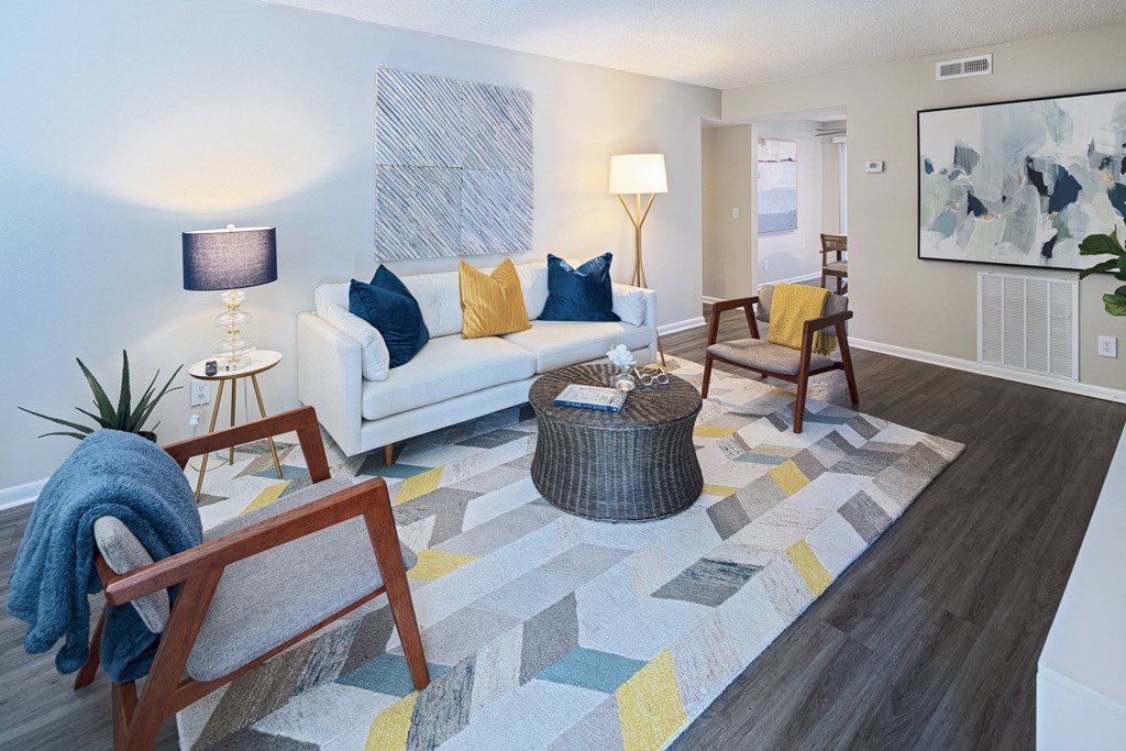 a living room with a couch and chairs and a rug