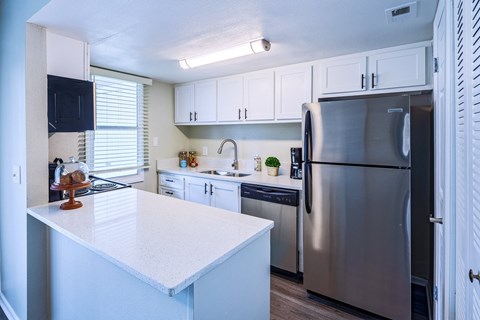 a kitchen with stainless steel appliances and white counter tops