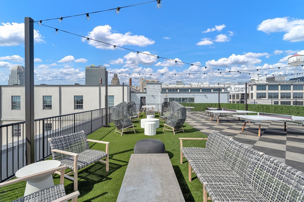 a rooftop patio with tables and chairs and a view of the city
