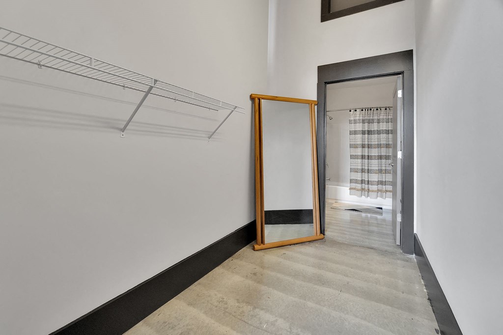 a mirror in a hallway with a white wall and a door