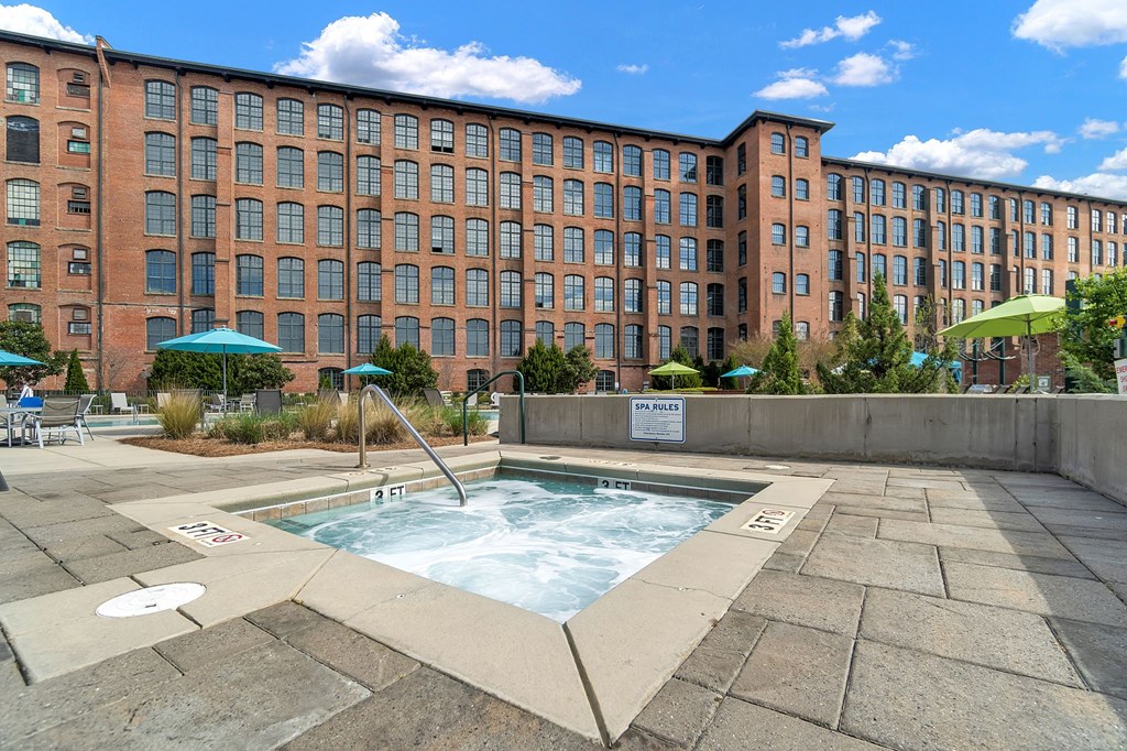 a hot tub with a large brick building in the background