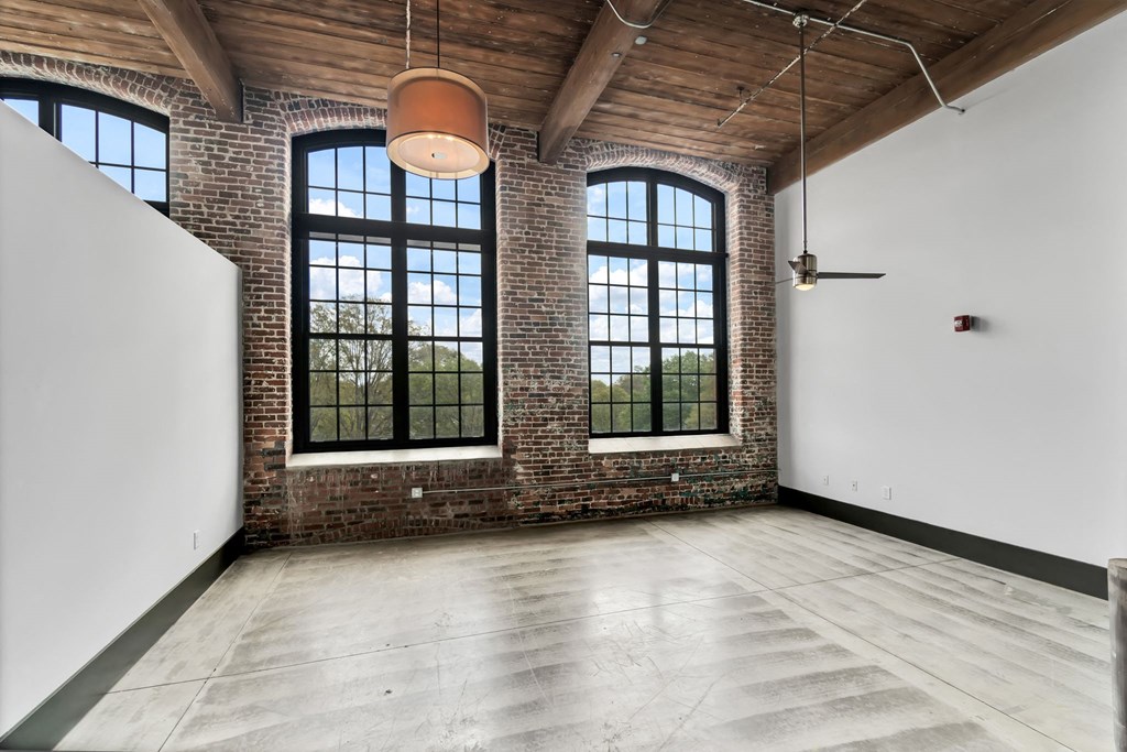 an empty room with large windows and a white wall