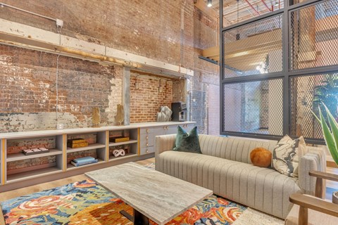 a living room with a couch and a table in front of a window
