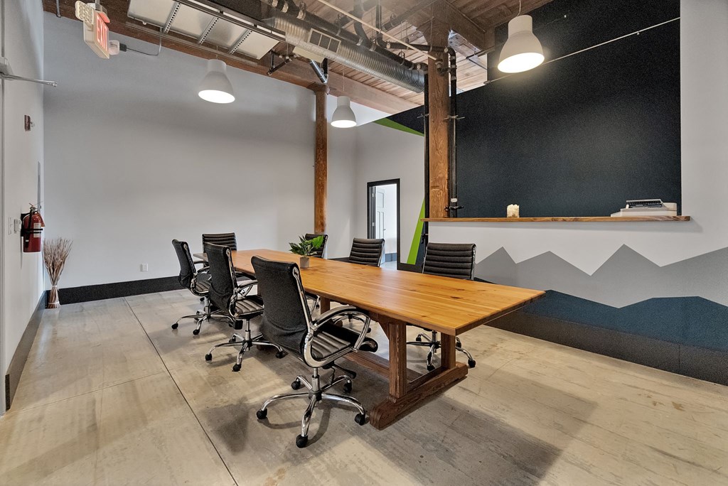 a conference room with a large wooden table and chairs