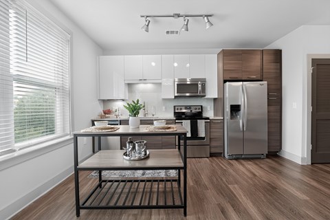 A modern kitchen with a wooden floor and stainless steel appliances.