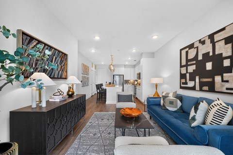 A living room with a blue couch and a black cabinet.