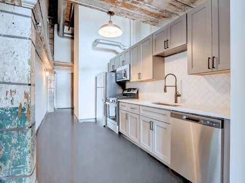 a kitchen with white cabinets and a gray floor