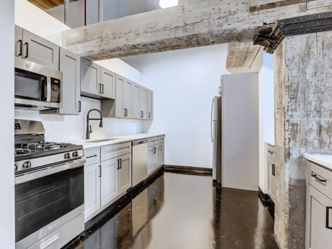 a kitchen with white cabinets and stainless steel appliances