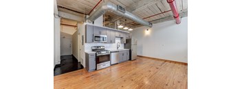 a kitchen with gray cabinets and a wood floor