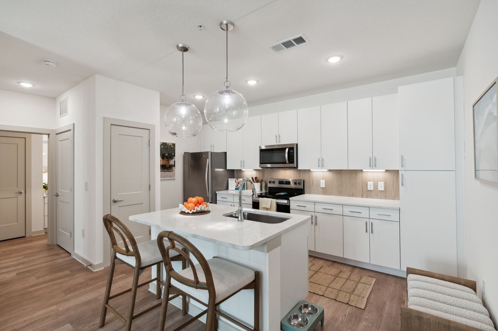 A modern kitchen with white cabinets and a center island.