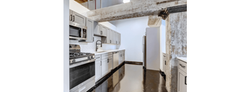 Historic Loft Style Studio in Cabbagetown With A Modern kitchen with white cabinets and stainless steel appliances