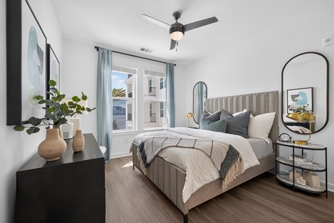 A bedroom with a large bed and a ceiling fan.