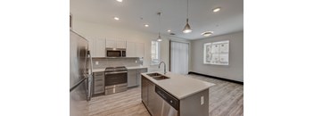 a kitchen with an island and stainless steel appliances