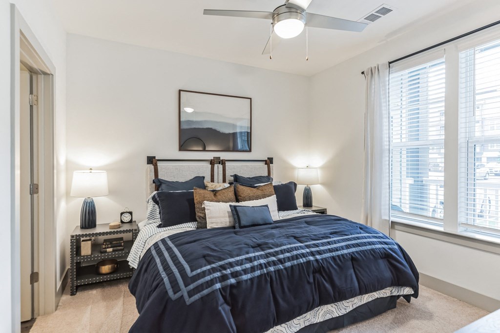 a bedroom with a bed and a ceiling fan