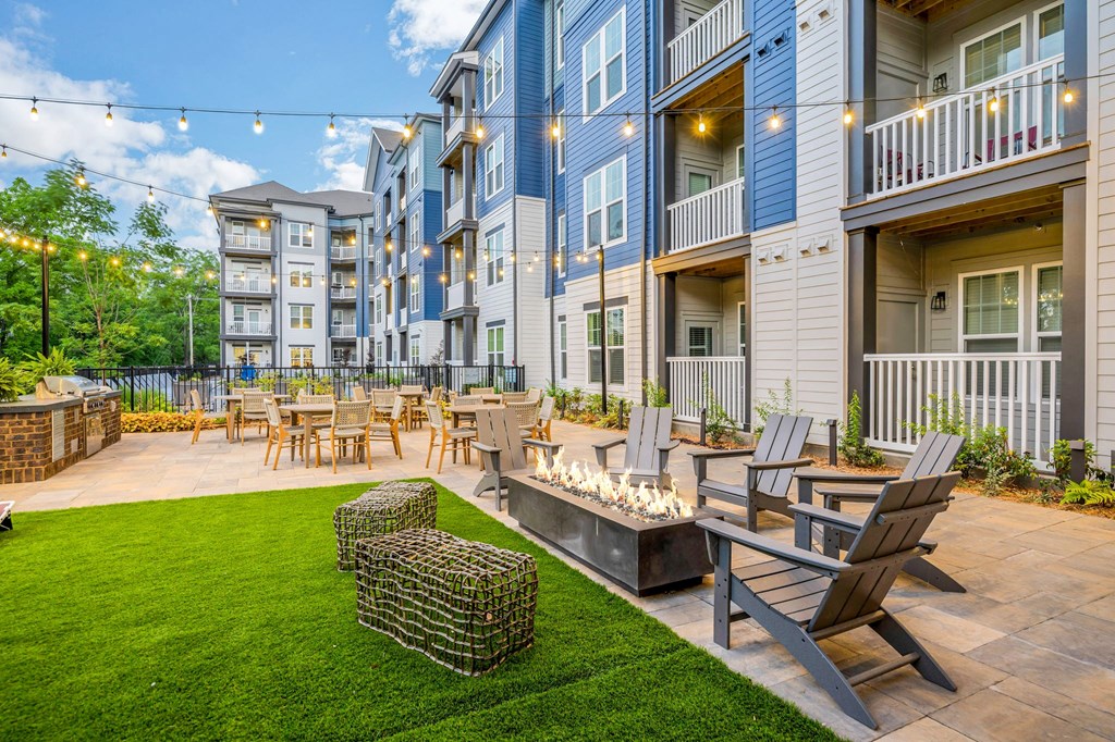 a patio with tables and chairs in front of an apartment building