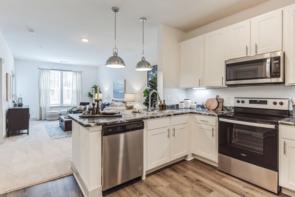 an open kitchen with stainless steel appliances and white cabinets