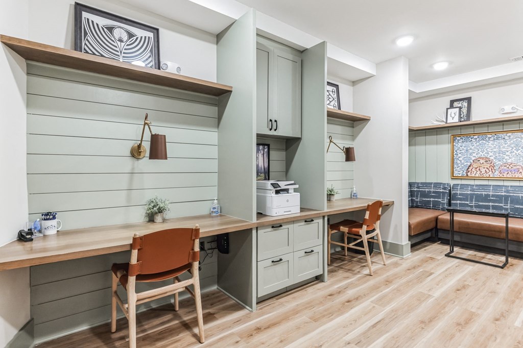 a home office with a desk and a counter with chairs
