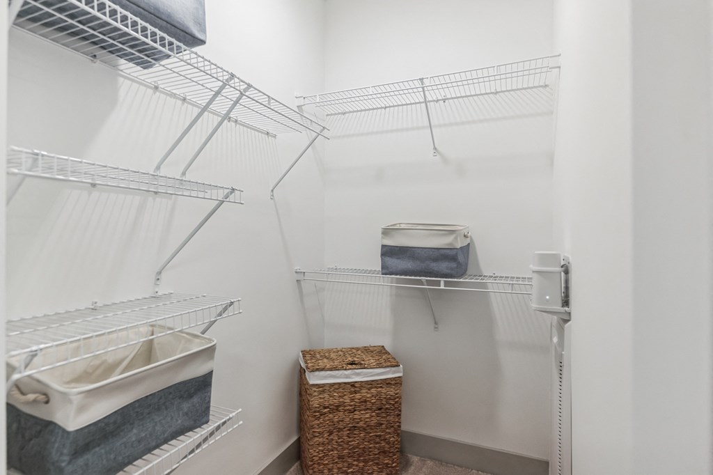 a walk in closet with shelves and baskets in a bathroom