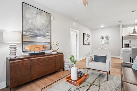 A living room with a large painting on the wall and a wooden cabinet.