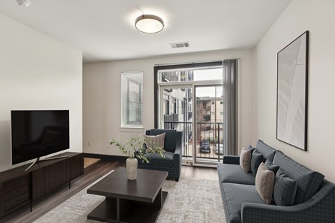 A living room with a grey couch and a flat screen TV.