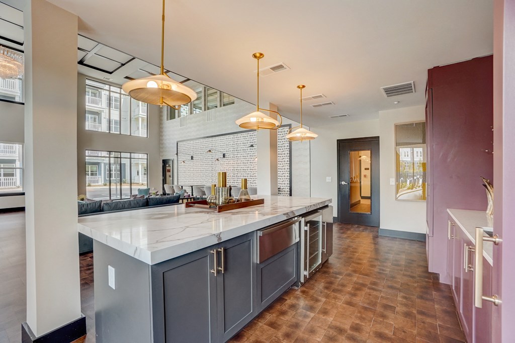 a kitchen with a large center island with a marble countertop