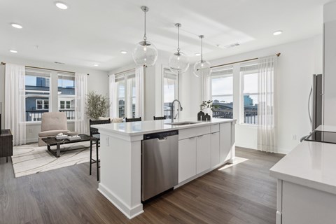A modern kitchen with white cabinets and a large island.