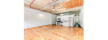 a kitchen and living room with hardwood floors and white walls