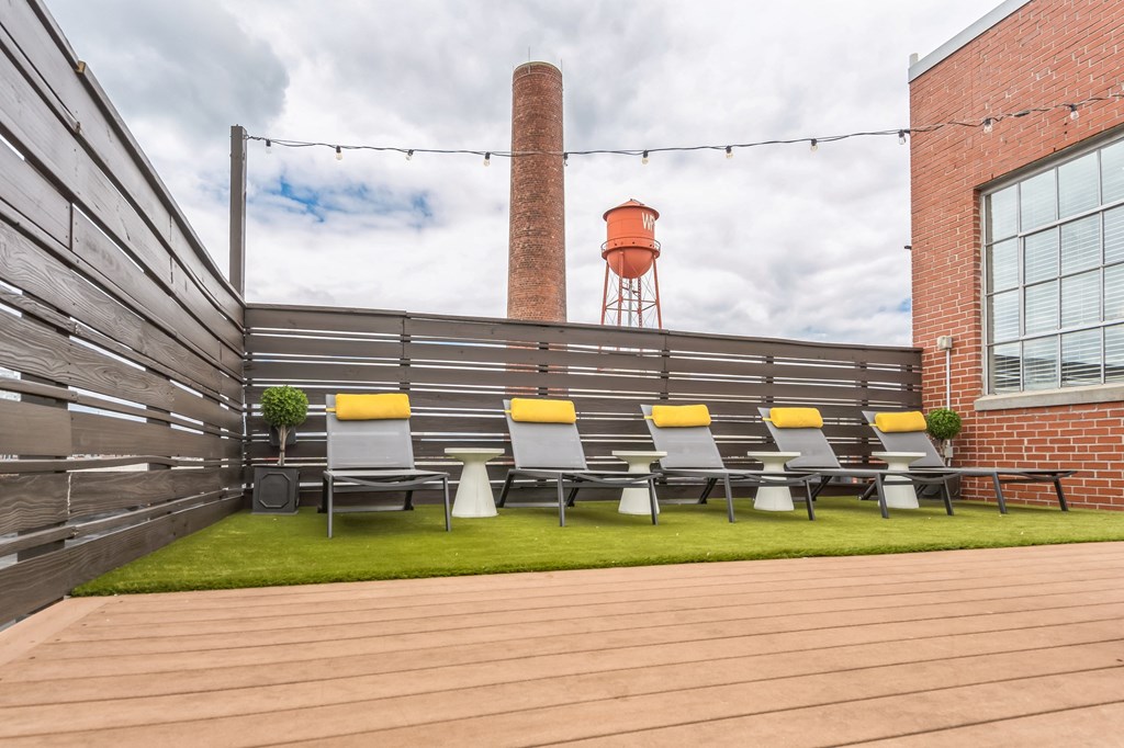 a patio with chairs and a water tower in the background