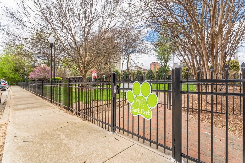 a fence with a sign on it on a sidewalk