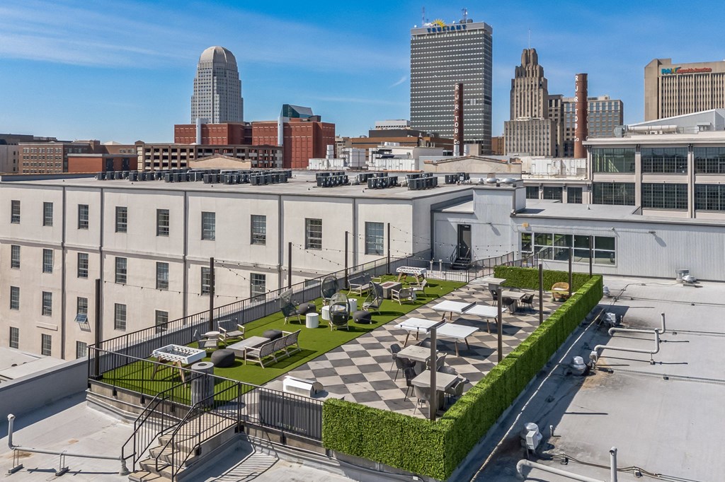 a roof terrace with tables and chairs on top of a building