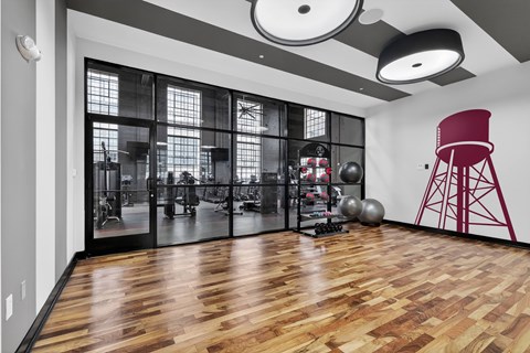 A gym with a red chair and a wooden floor.