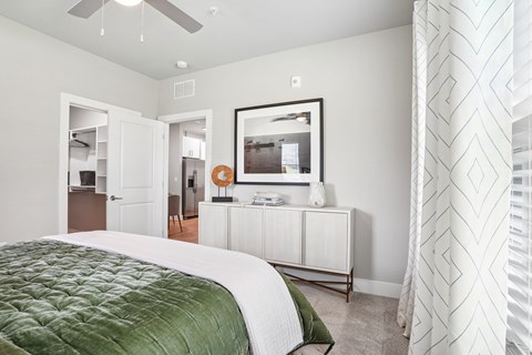 A bedroom with a large bed and a mirror on the wall.