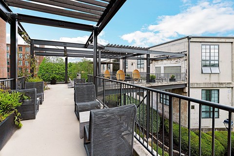 A patio with a black railing and a black metal roof.