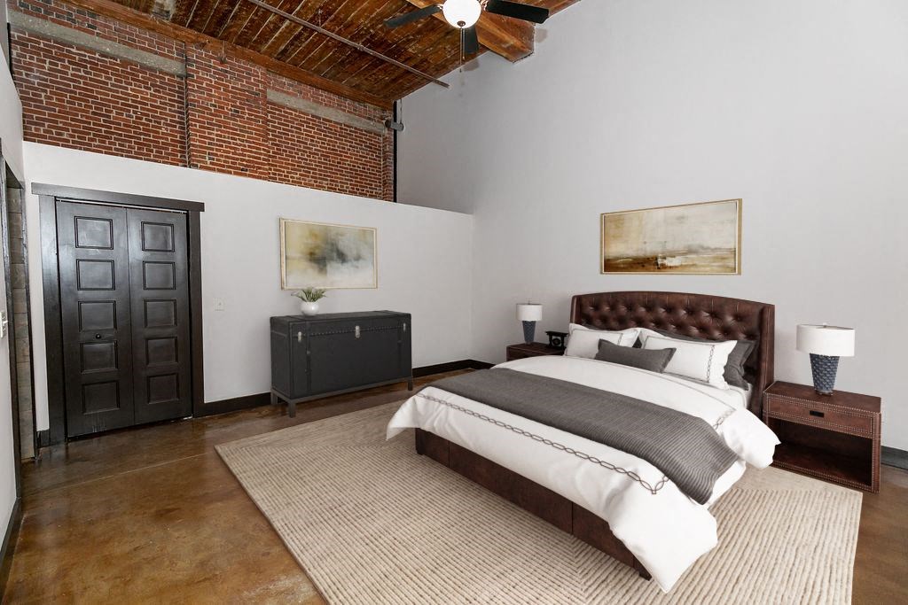 a bedroom with a bed and a exposed brick wall
