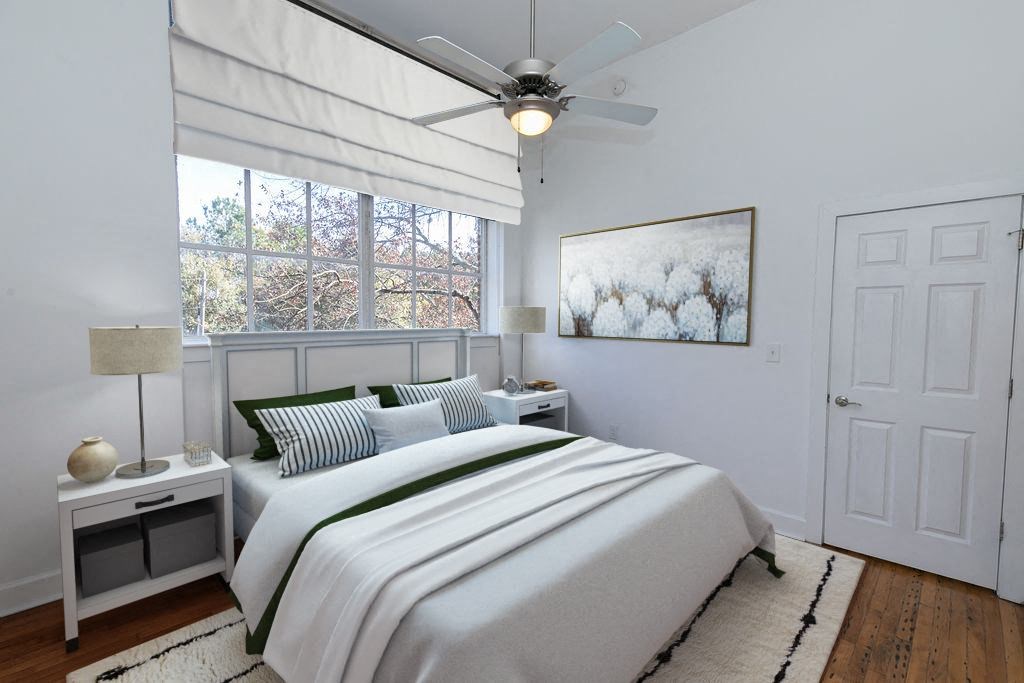 a white bedroom with a bed and a ceiling fan