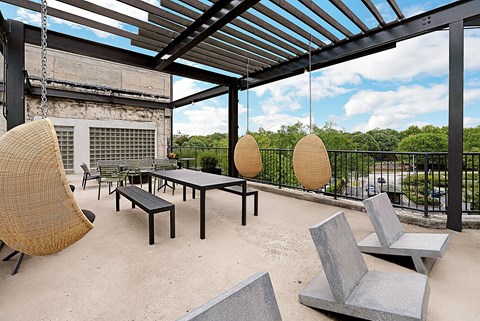 A patio with a table, chairs and a fence.