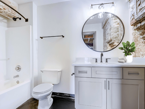 a bathroom with white cabinets and a white toilet