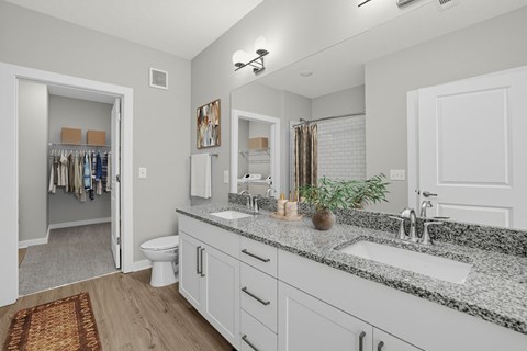 A bathroom with a toilet, sink, and mirror.