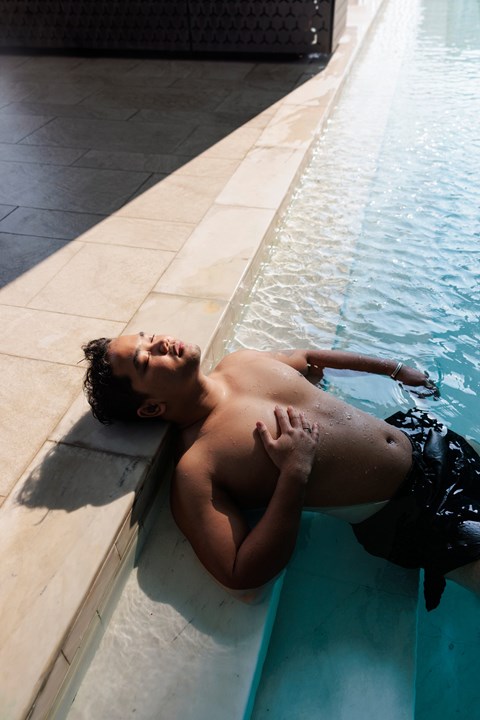 A man is sunbathing in a pool.