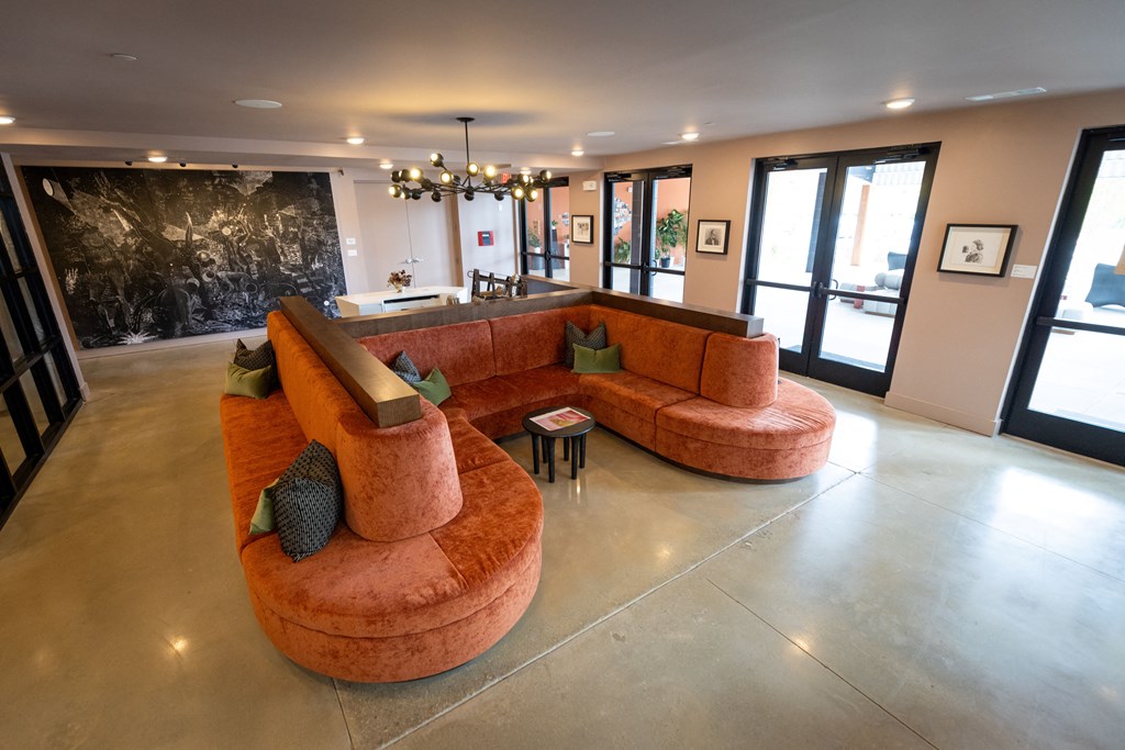 a large living room with a orange couch and a marble floor