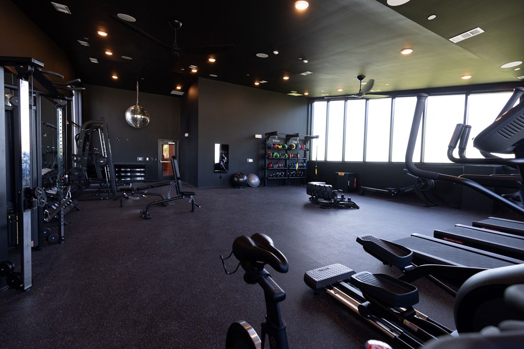 a gym with exercise equipment and large windows