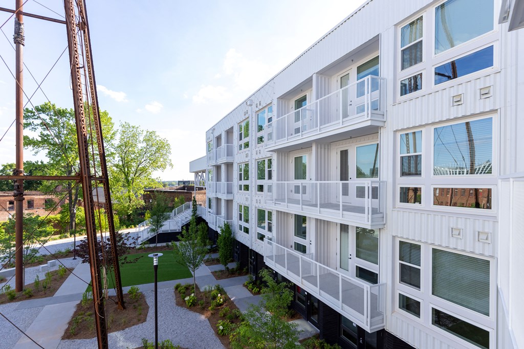 a large white building with balconies and a walkway