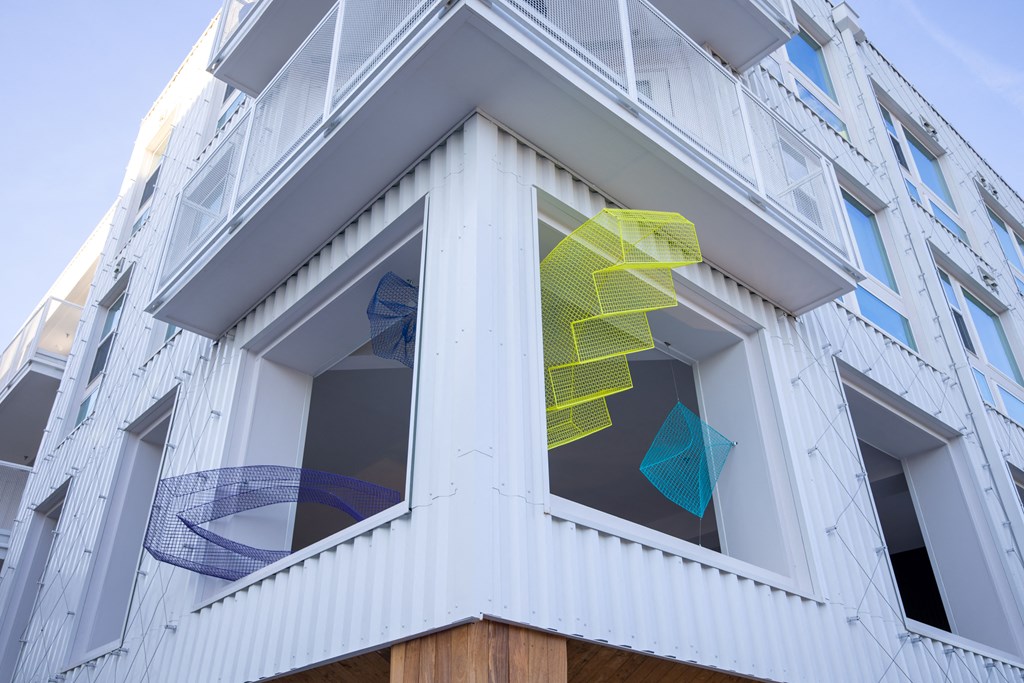 the windows of a white building with blue and yellow triangles on the windows